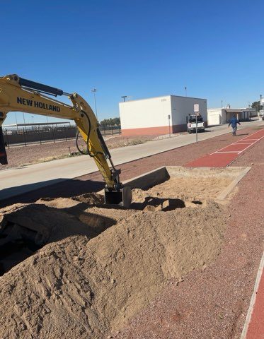 Excavator grading a commercial lot after demolition