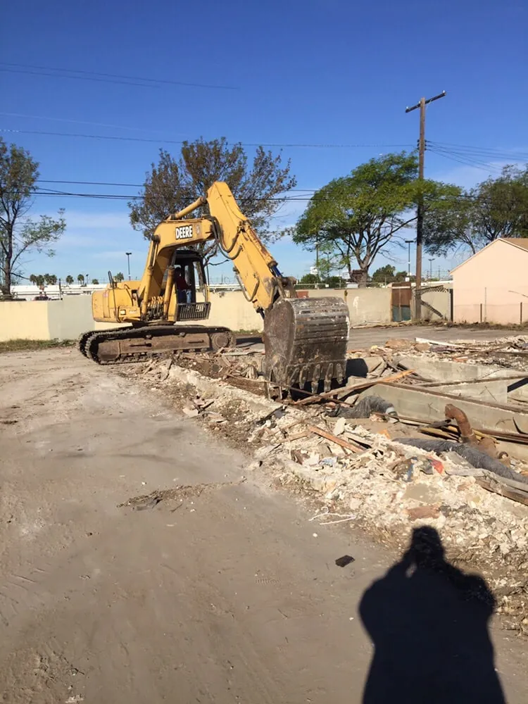 Excavator demolishing a structure during a full demolition job in Phoenix, AZ